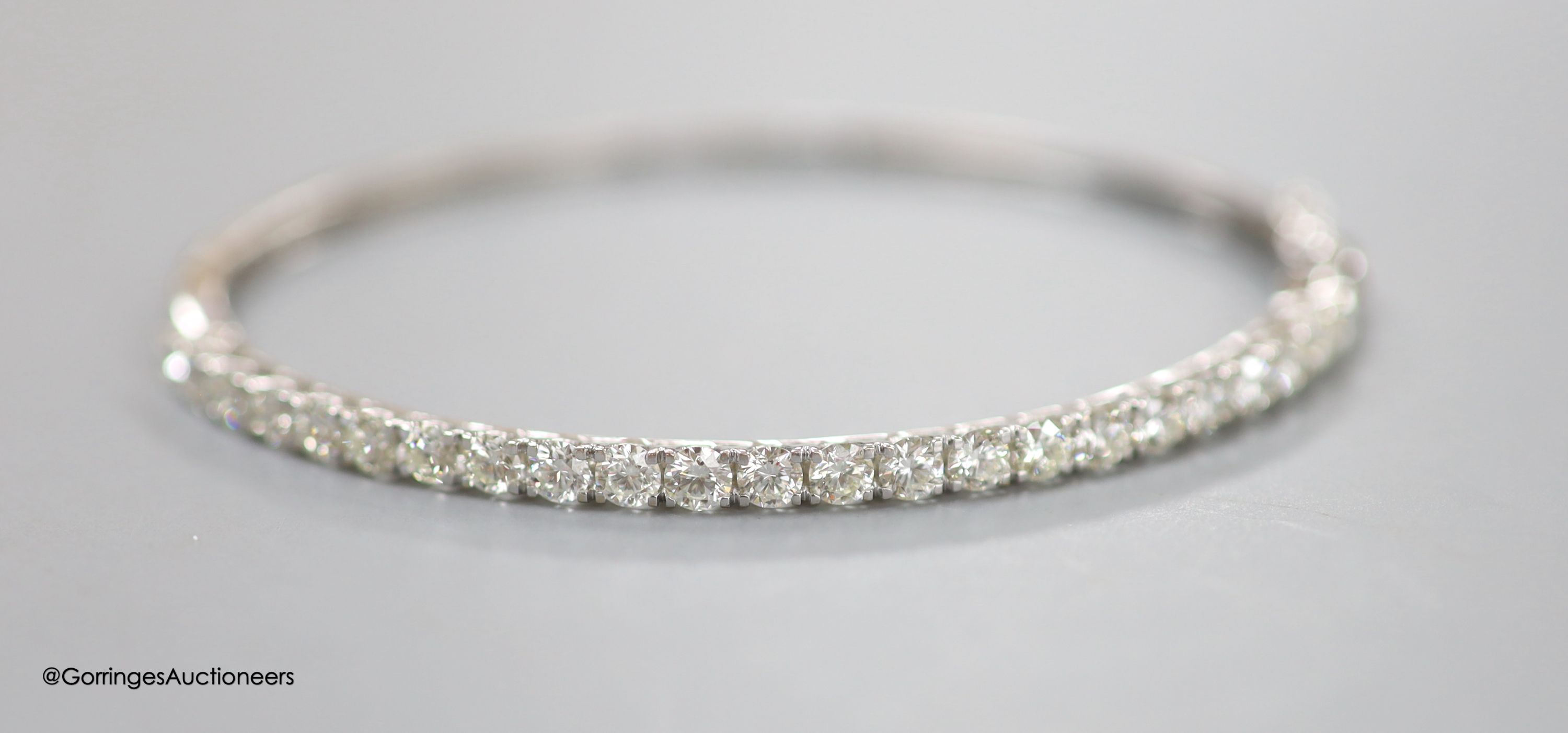 A modern 18ct white gold and twenty three stone diamond set hinged bracelet, gross 9.2 grams